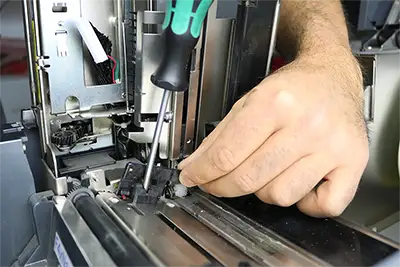 Ein Techniker repariert einen Drucker in einem unserer Reparaturzentren.